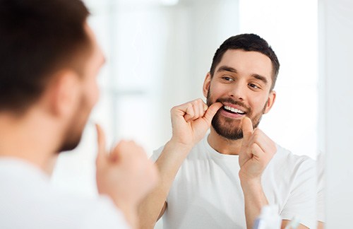 a man flossing is teeth