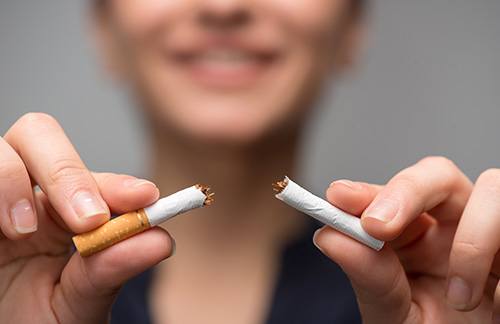 a person breaking a cigarette in half