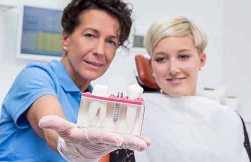 Woman discussing dental implant with dentist