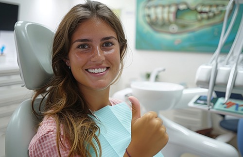 Smiling dental patient making thumbs up gesture